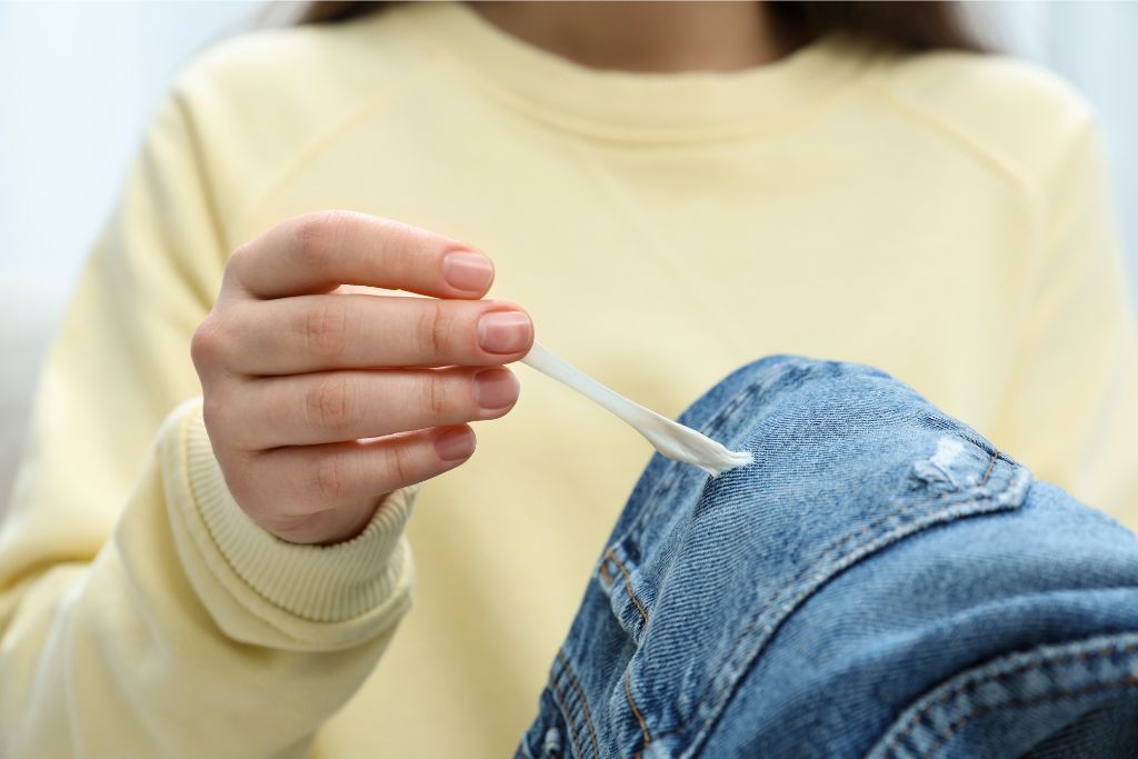 A close-up of someone peeling gum off their jeans, a stark reminder of Singapore's unusual yet effective law banning chewing gum. This is one of the weird laws in Singapore aimed at keeping public spaces clean—something every visitor should know before traveling.