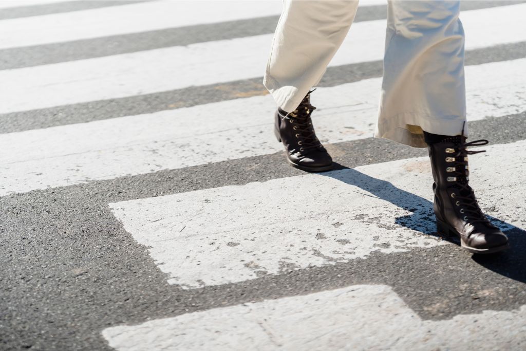 A person confidently walking across a pedestrian crossing, showcasing how seriously Singapore takes road safety. Jaywalking isn’t just discouraged here—it’s illegal, and one of the strict laws in Singapore that comes with hefty fines.