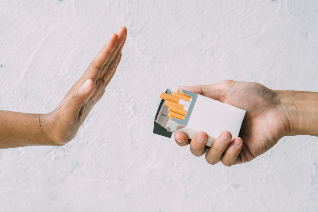 A hand rejecting a cigarette pack against a plain background, symbolizing Singapore’s tough stance on smoking. Designated smoking areas and strict regulations make this one of the key laws in Singapore to know for a hassle-free trip.