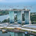 A breathtaking aerial view of Marina Bay Sands and the surrounding waterfront. This modern marvel is a symbol of Singapore’s meticulous planning and the strict travel rules that maintain the city’s seamless urban experience.