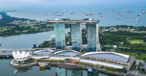 A breathtaking aerial view of Marina Bay Sands and the surrounding waterfront. This modern marvel is a symbol of Singapore’s meticulous planning and the strict travel rules that maintain the city’s seamless urban experience.