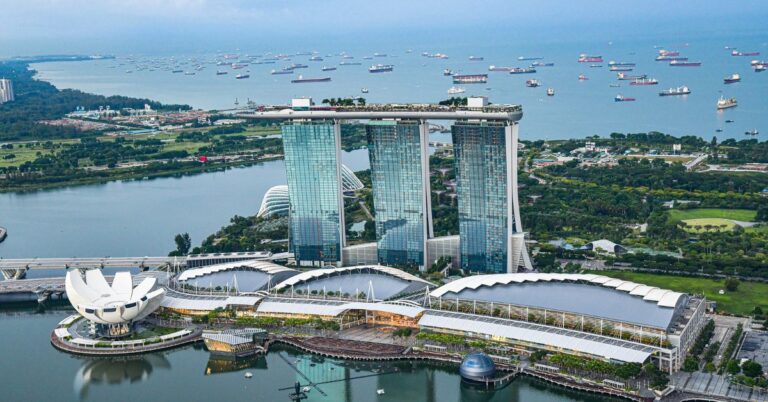 A breathtaking aerial view of Marina Bay Sands and the surrounding waterfront. This modern marvel is a symbol of Singapore’s meticulous planning and the strict travel rules that maintain the city’s seamless urban experience.