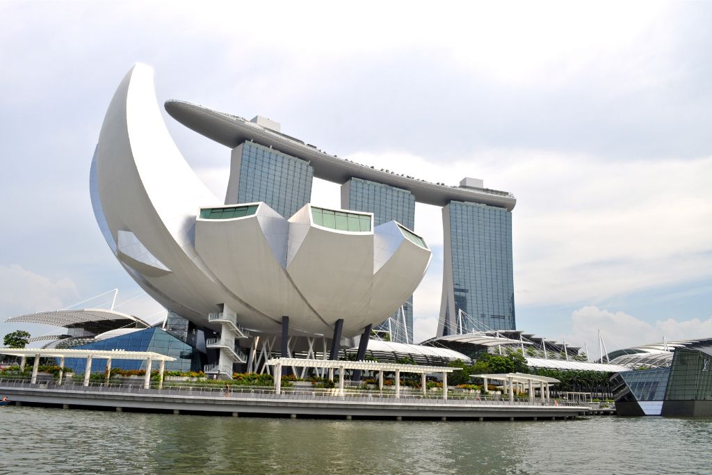 The iconic Marina Bay Sands with the futuristic ArtScience Museum in the foreground, reflected in the calm waters. A must-visit spot for winter travel in Singapore.