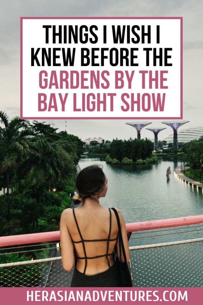 A woman in a strappy black dress overlooks the water and distant Supertrees at Gardens by the Bay during dusk, with text reading “Things I Wish I Knew Before the Gardens by the Bay Light Show.” This visual teaser highlights essential tips for visiting the Garden Rhapsody, one of the most iconic light shows in Singapore.