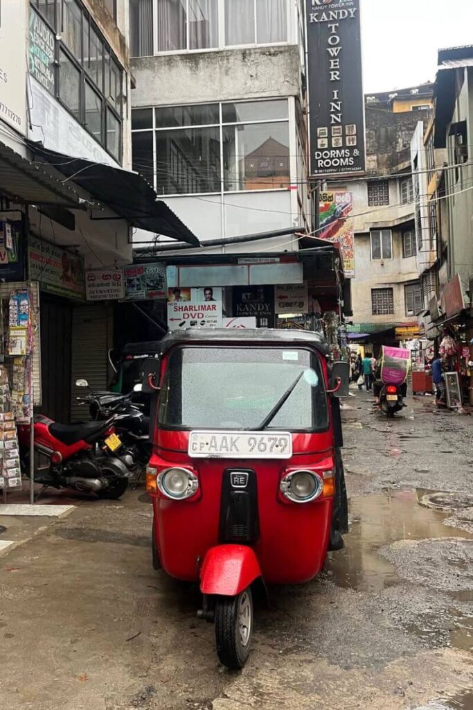 A red tuk-tuk parked in a lively, narrow street in Sri Lanka, ideal for showcasing best solo travel spots and emphasizing how to convince your parents to let you fly alone and explore culturally rich places safely.