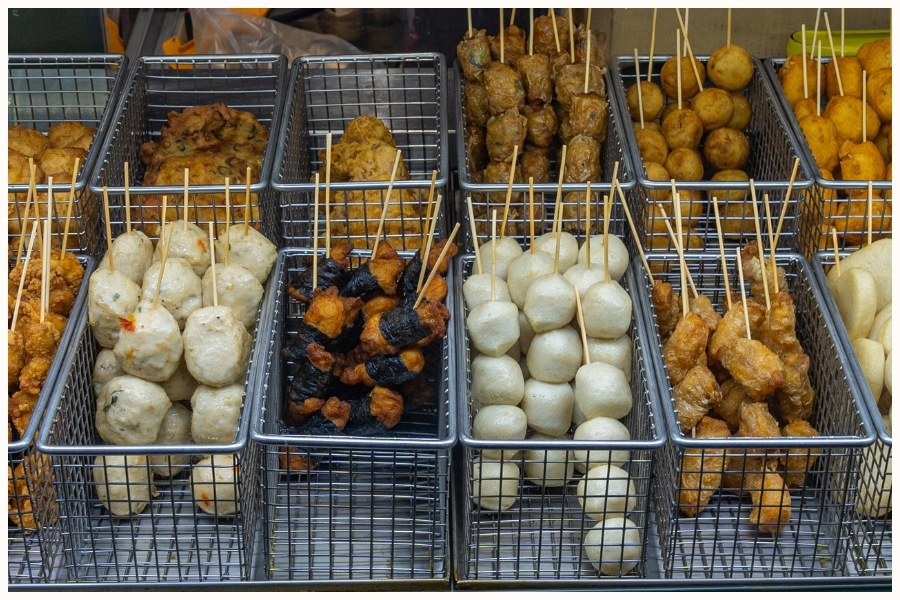 Various skewered items displayed in baskets at a hawker stall. This image represents Singapore street food and top hawker food, showcasing the diverse offerings at Singapore food markets.