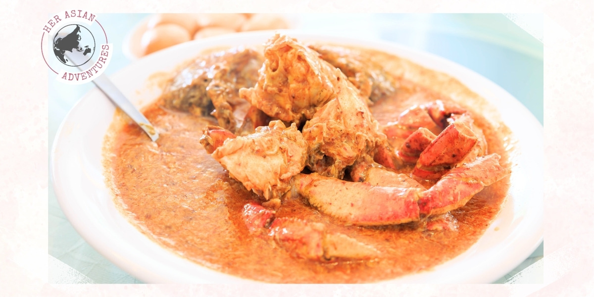 A plate of rich, spicy chili crab, a signature Singaporean dish, served at a hawker center. This image highlights the best hawker food in Singapore, a must-try for anyone exploring what to eat in Singapore.