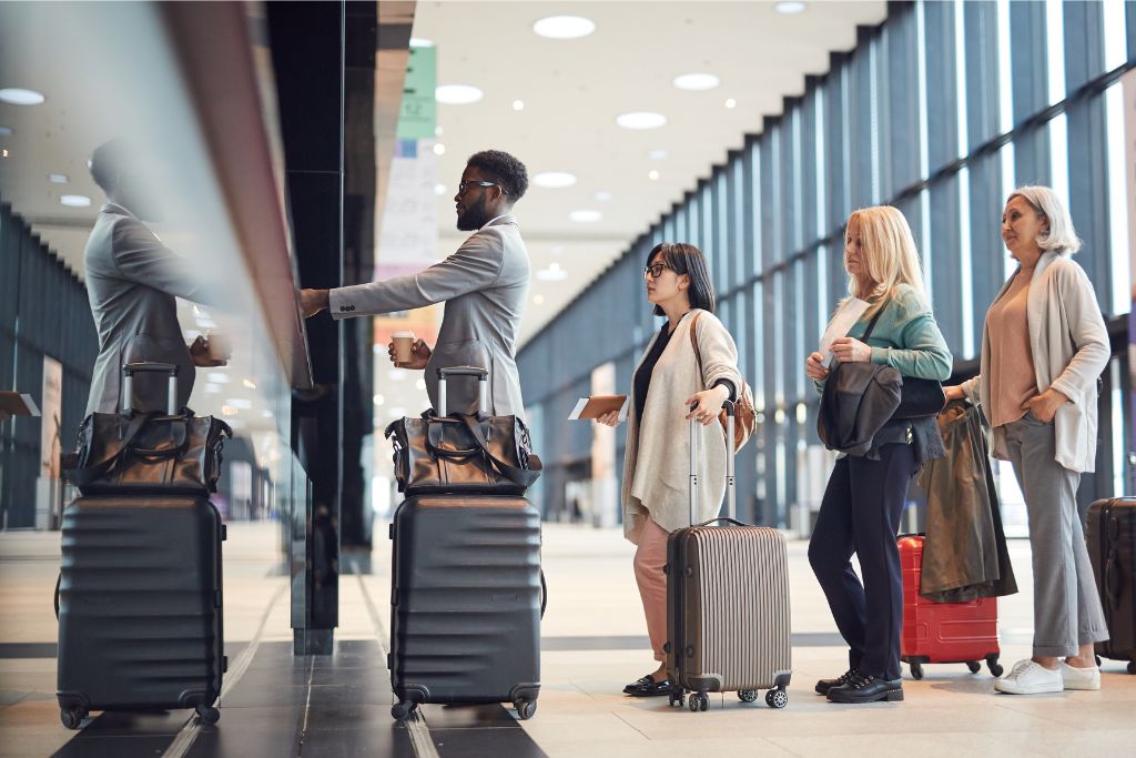 A group of travelers with luggage standing at a check-in counter at the airport. Perfect example of airport procedures for first time flyers, highlighting essential travel tips for solo travelers and domestic flight preparation.