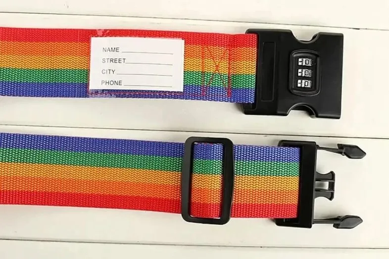 A colorful rainbow luggage strap with a combination lock and a label section for personal information. Using bright, distinctive straps with security features is a practical and fun way to make your luggage stand out and protect it from theft.