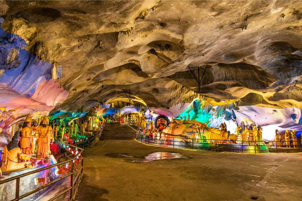 The illuminated statues inside Batu Caves temple, with intricate carvings and vibrant lighting creating a breathtaking atmosphere. Batu Caves, part of many Batu Cave tours, showcases stunning religious art and is a major Kuala Lumpur attraction.