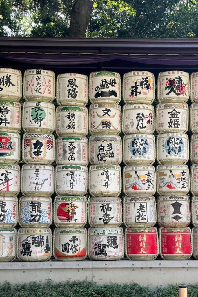 Rows of colorful sake barrels with Japanese writing displayed at a shrine in Tokyo. Visiting this spot is one of the most cultural autumn destinations Asia travelers can enjoy during fall in Japan.