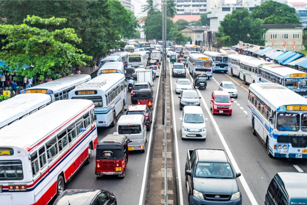 A bustling highway in Sri Lanka filled with buses, cars, and tuk tuks. Tuk tuks are one of the best ways to navigate traffic and explore the hidden gems of the island, with tuk tuk rentals widely available.