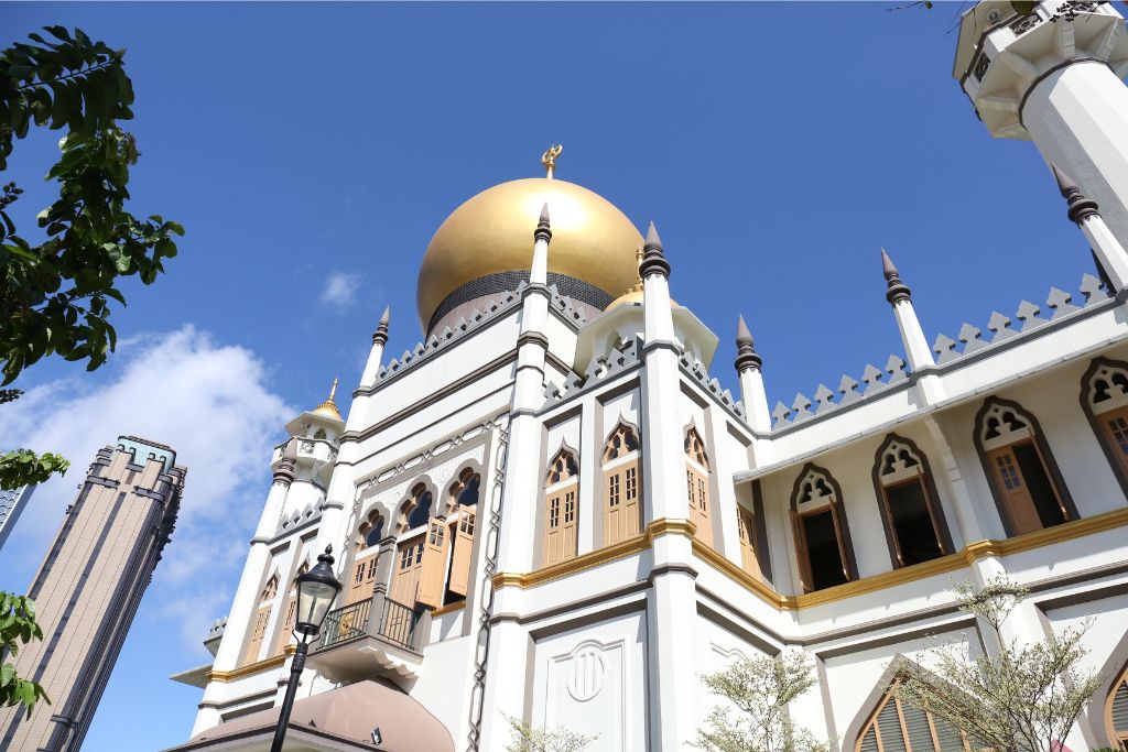 The Sultan Mosque, with its iconic golden dome, stands against a clear blue sky. This is one of the reasons to visit Singapore for its rich cultural landmarks, highlighting why Singapore is worth visiting for a unique travel experience.