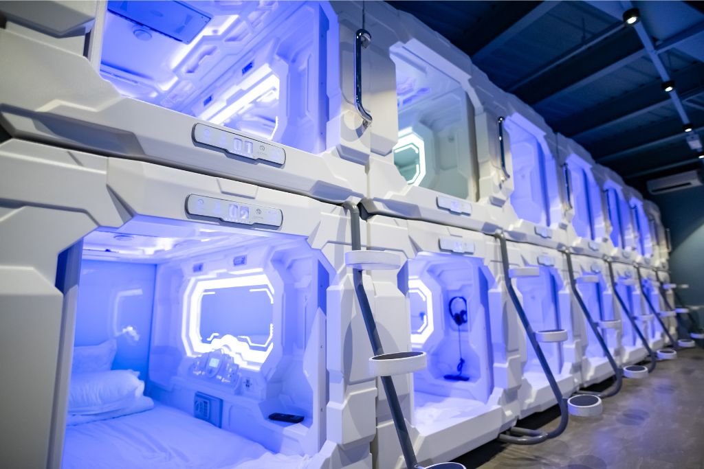 Rows of futuristic capsule beds inside a capsule hotel in Singapore. For travelers looking for unique and affordable accommodations, this is a reason why Singapore is worth it, offering innovative lodging options.