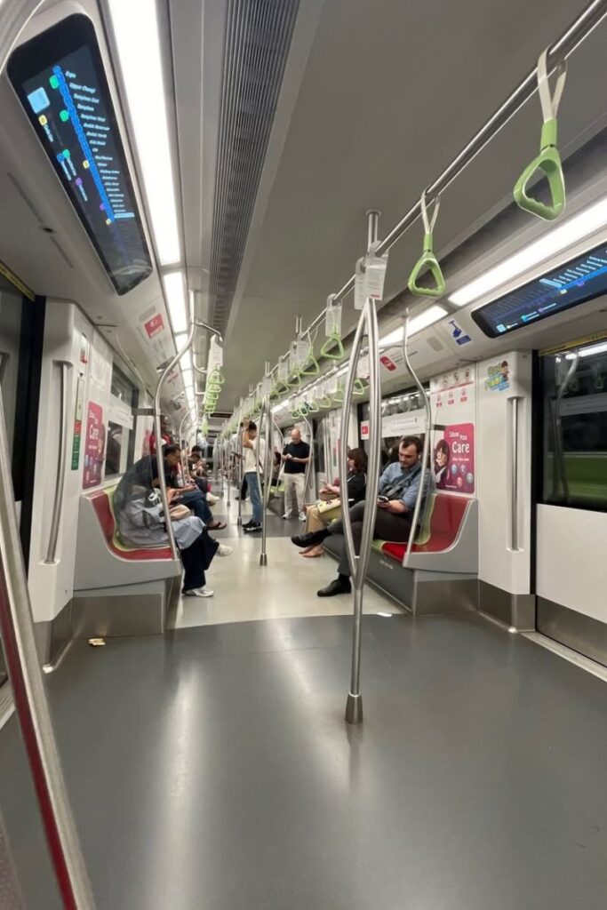 Interior of a clean, modern MRT train in Singapore, with seated locals and clear signage. Singapore’s efficient public transportation is one reason why travel to Singapore is so easy, especially for first-time visitors or families with kids.