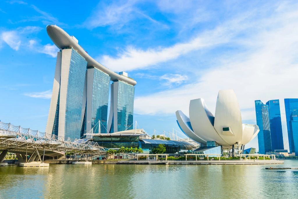 Daytime view of the futuristic Marina Bay Sands and lotus-shaped ArtScience Museum across Marina Bay. These iconic landmarks are top reasons to go to Singapore and essential to any Singapore vacation itinerary.