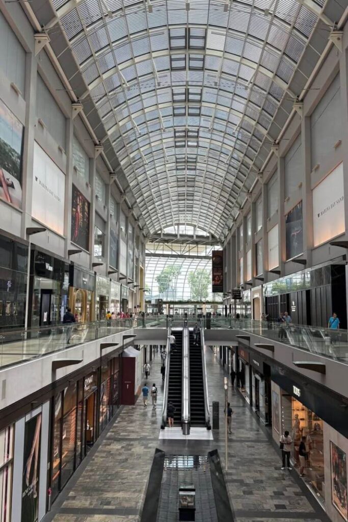 High-end retail shops line the glass-roofed interior of The Shoppes at Marina Bay Sands, one of Singapore’s premier luxury malls. Whether you're traveling in December for shopping or sightseeing, this upscale destination is a popular reason to go to Singapore.