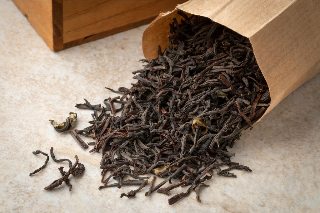 Loose-leaf black tea spilling from a brown paper bag, representing one of Sri Lanka’s renowned exports. This premium tea makes an excellent gift from Sri Lanka for tea lovers.