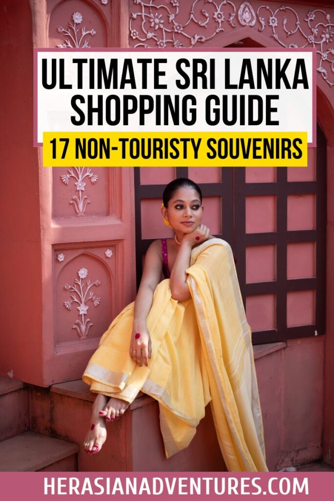 A woman in traditional Sri Lankan attire sits against an ornate pink wall, representing authentic, non-touristy gifts from Sri Lanka. Text overlay says, "Ultimate Sri Lanka Shopping Guide – 17 Non-Touristy Souvenirs," for a curated guide to unique Sri Lanka gifts.