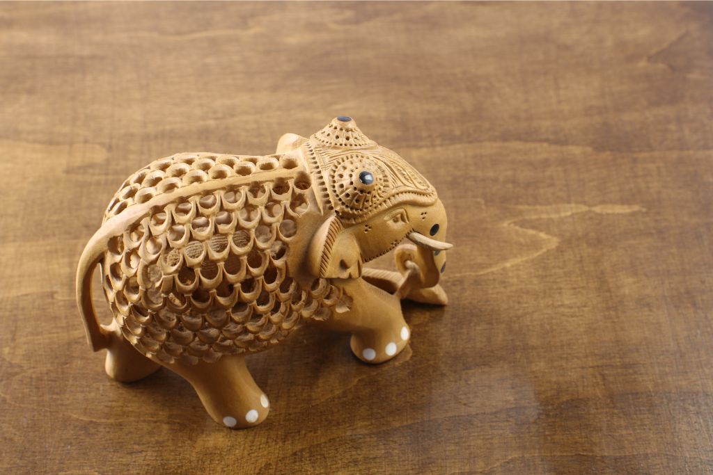 A delicately carved wooden elephant figurine with ornate patterns, symbolizing Sri Lankan artistry. This intricate sculpture makes a beautiful and culturally rich gift from Sri Lanka.