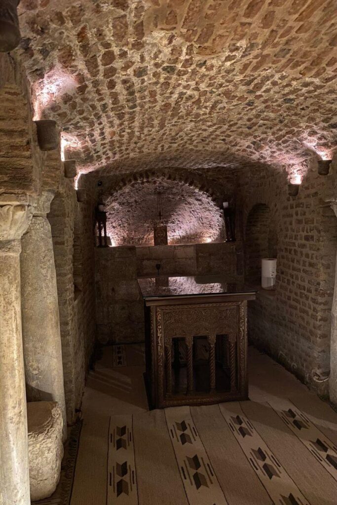 A dimly lit underground chapel with arched brick ceilings and a wooden altar, showcasing Coptic architecture in the historic Abu Serga Church in Coptic Cairo, a renowned Christian pilgrimage site in Ancient Cairo.