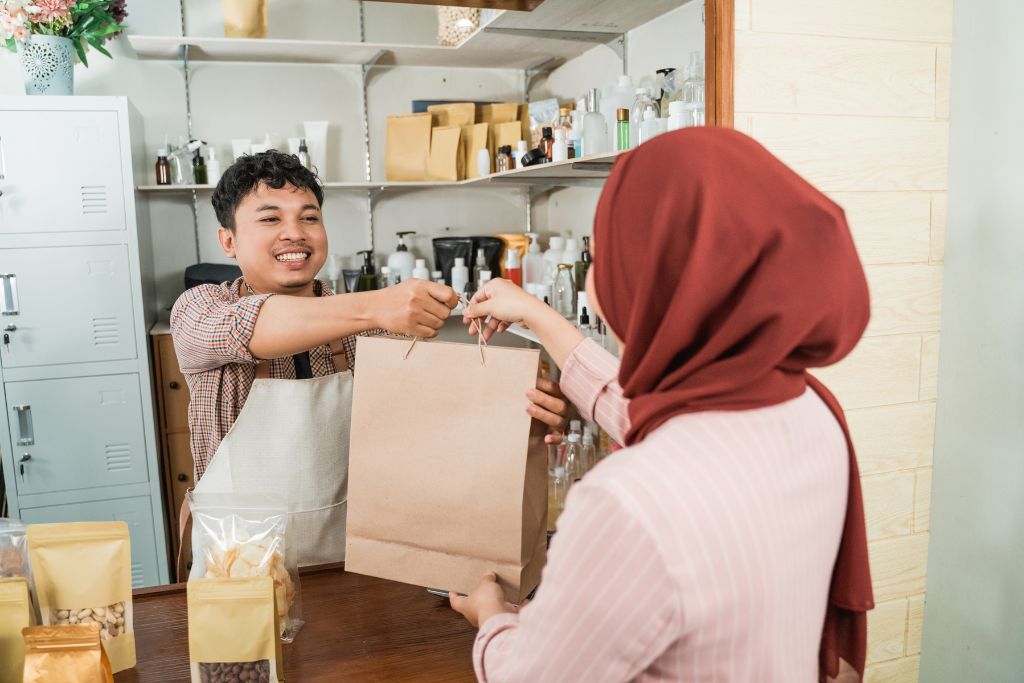 A cheerful vendor handing over a purchase to a customer, illustrating friendly interactions and practical haggling tips for negotiating prices abroad.