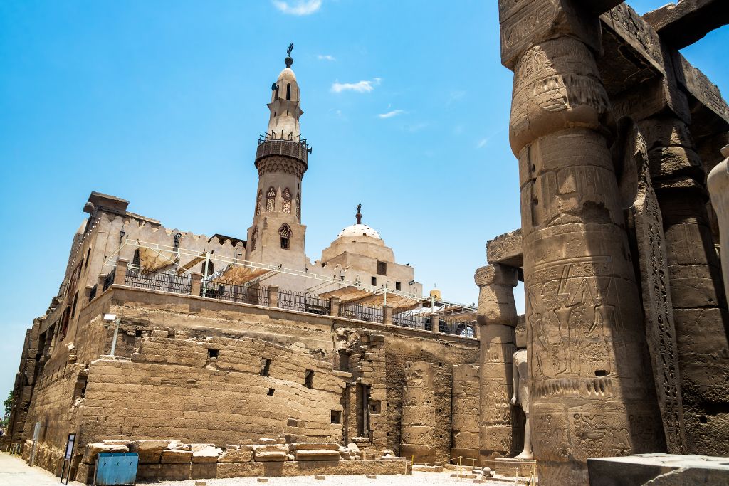 A view of Abu Haggag Mosque in Luxor, Egypt, set atop ancient ruins with intricate stone carvings, showcasing the blend of Islamic architecture and historical Egyptian influences