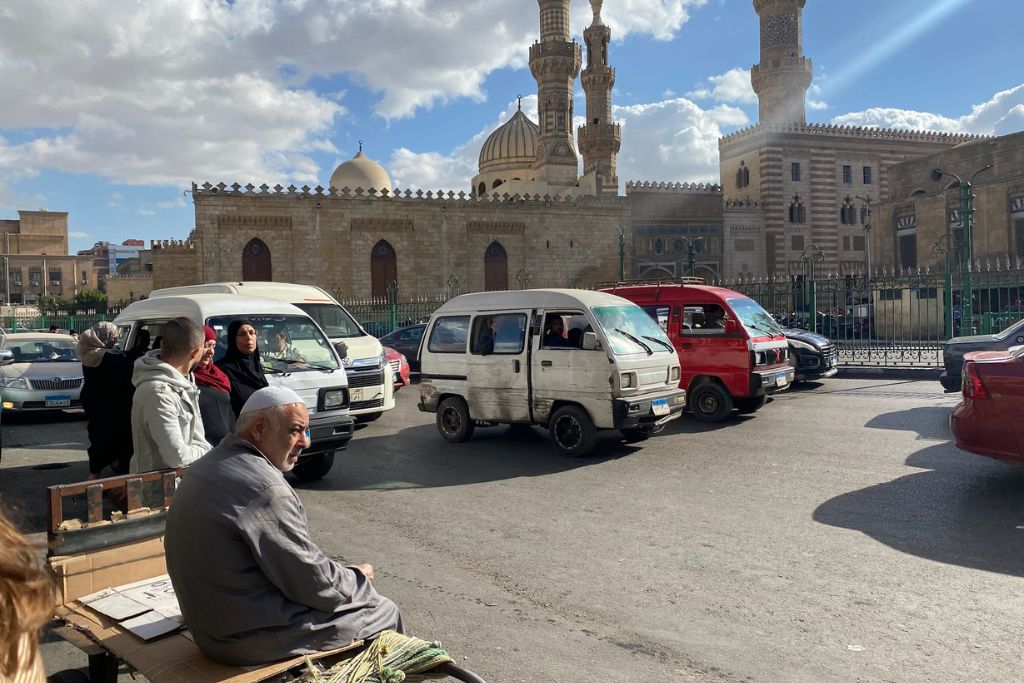 A street view near the Khan el Khalili bazaar, with locals and tourists navigating Cairo’s lively market area, surrounded by historic architecture and street vendors.