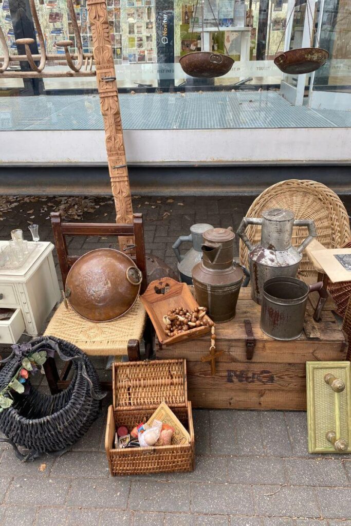 A collection of rustic and antique household items displayed for sale at a flea market. Understanding the first rule of haggling—never accept the first price—can help you negotiate a deal. Bartering here could lead to great savings.