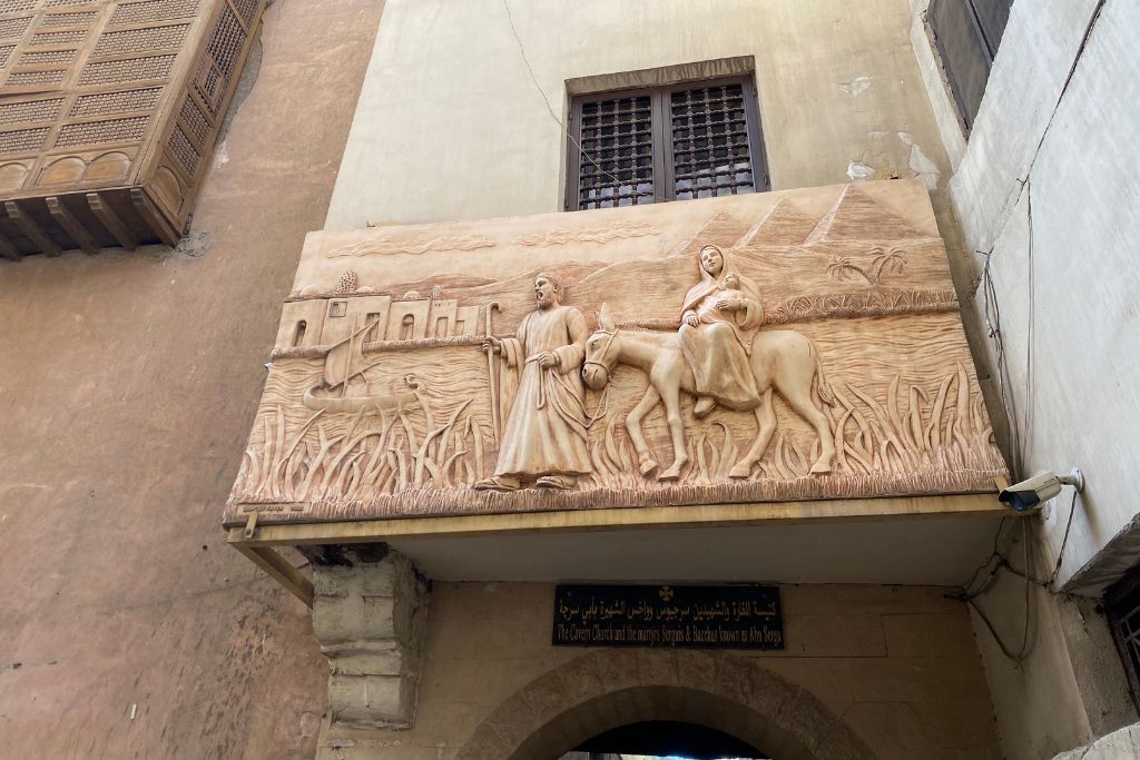 A carved stone relief depicting the Holy Family’s journey through Egypt, located in the Coptic Quarter, symbolizing the deep connection between Biblical history and Christianity in Egypt.