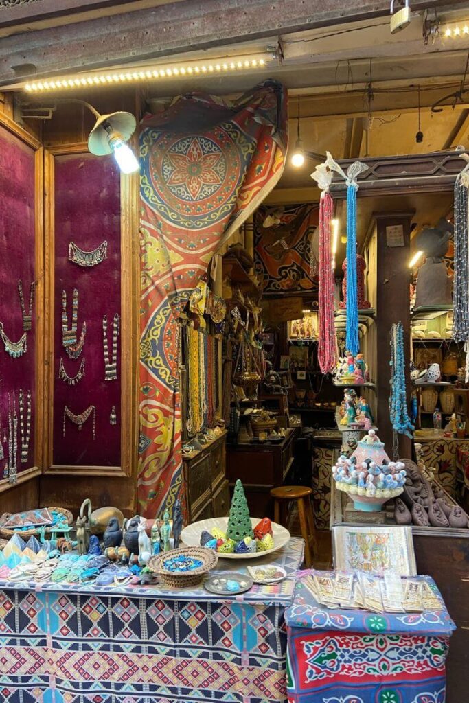 A colorful display of handmade jewelry, ceramics, and patterned textiles at a shop in Khan el Khalili bazaar, embodying the rich craftsmanship of Cairo, Egypt.