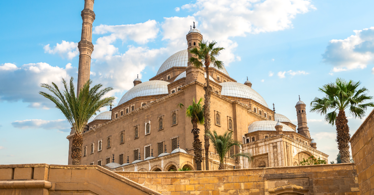 The iconic Muhammad Ali Mosque in Cairo, Egypt, with its grand domes and towering minarets surrounded by palm trees. A landmark of Islamic architecture, it symbolizes Cairo's rich historical and religious heritage.