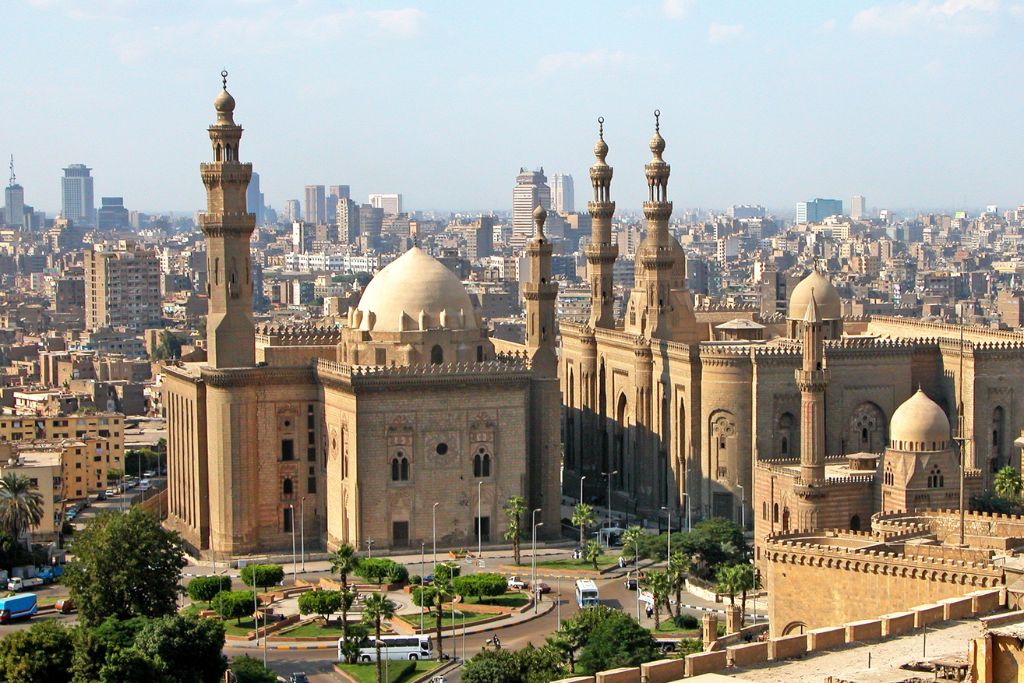 The Sultan Hassan Mosque and Al-Rifa’i Mosque in Cairo, captured against the backdrop of the bustling city skyline.