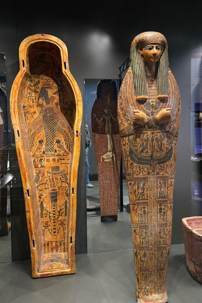 A detailed ancient Egyptian sarcophagus displayed in a museum, with intricate hieroglyphic carvings and colorful patterns. Learning about Egyptian burial practices and who built the Pyramids of Giza enhances the understanding of Pyramids of Giza facts.