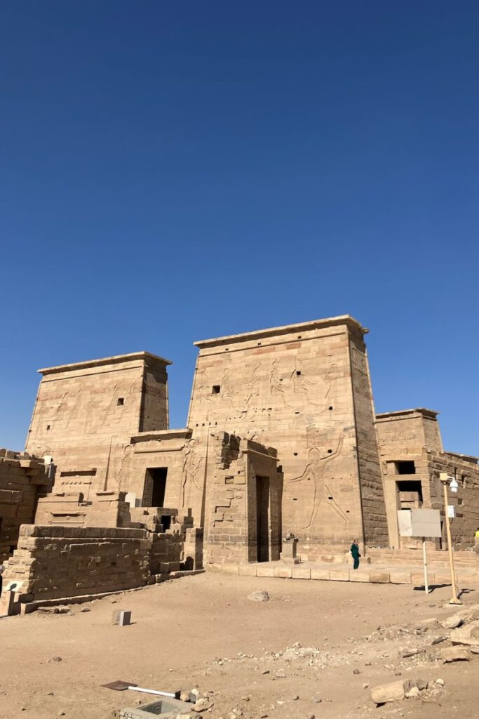 Front view of the Temple of Philae in Aswan, Egypt, showcasing its monumental pylons etched with scenes from Philae temple history, part of the famous Temple of Isis Egypt.