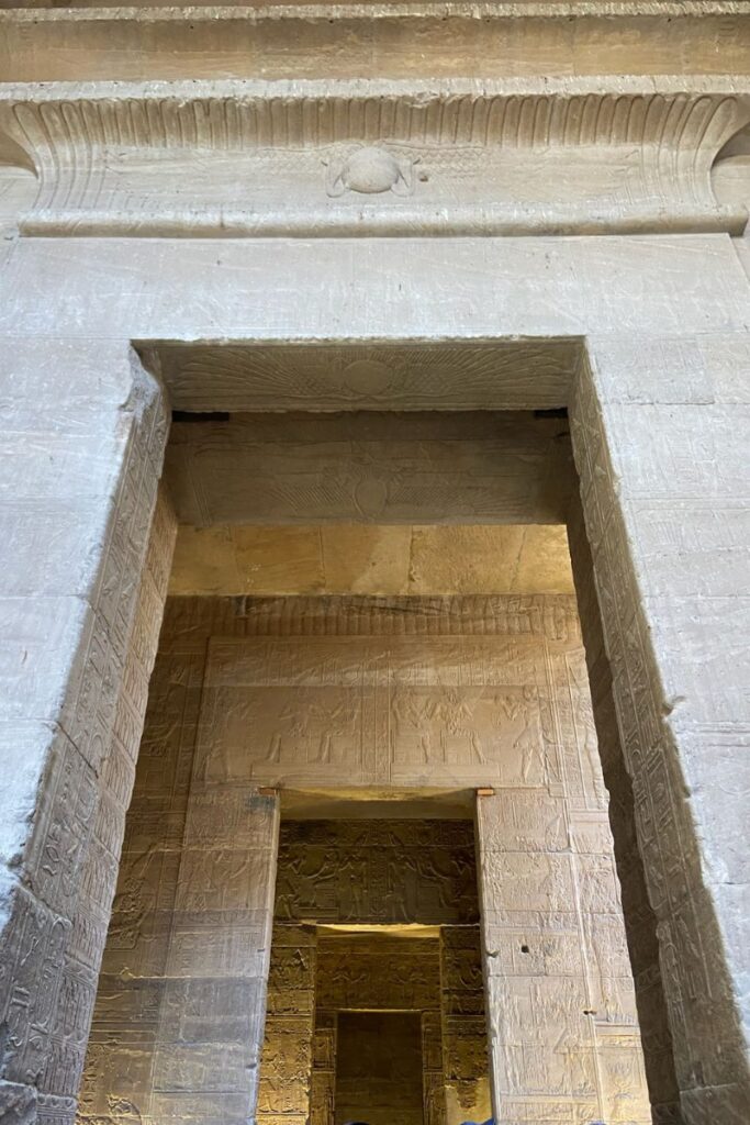 Architectural interior of the Temple of Isis at Philae, Egypt, showing a series of aligned doorways engraved with hieroglyphs, illustrating the precise design of the Temple of Philae.