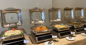 Buffet spread showcasing white rice, beef fricassee, sautéed vegetables, and mixed vegetable dishes in warming trays—this variety of Egyptian foods is a great example of what to eat in Egypt, offering flavorful Egyptian dishes perfect for any traditional meal.