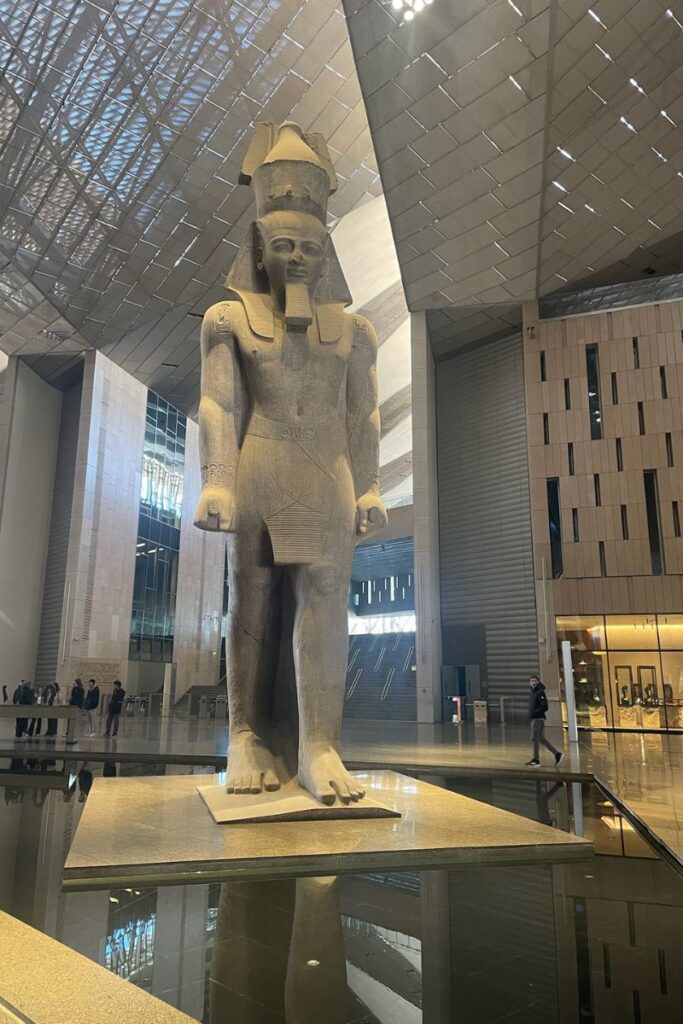 A towering statue of Ramses II stands inside the sleek, modern Grand Egyptian Museum. The contrast of ancient and modern showcases why travel to Egypt is a unique cultural journey.