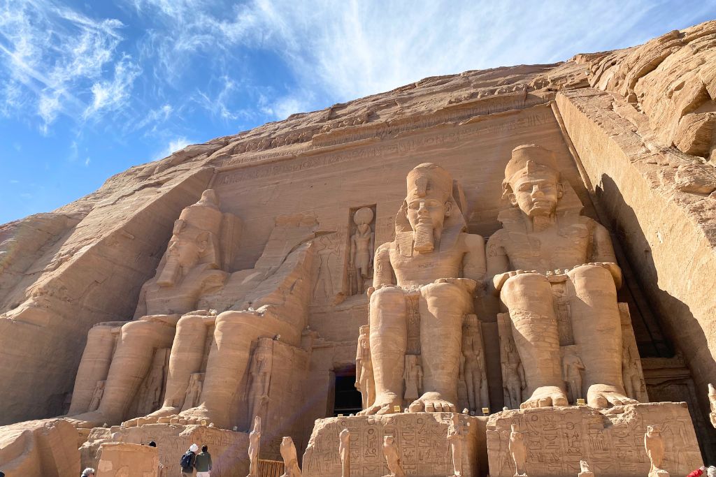 Majestic rock-cut statues of Ramses II at the entrance of Abu Simbel Temple in southern Egypt, under a bright blue sky. Useful for tourists wondering “is there Uber in Egypt” when planning long-distance travel or comparing Uber in Egypt price to organized excursions.