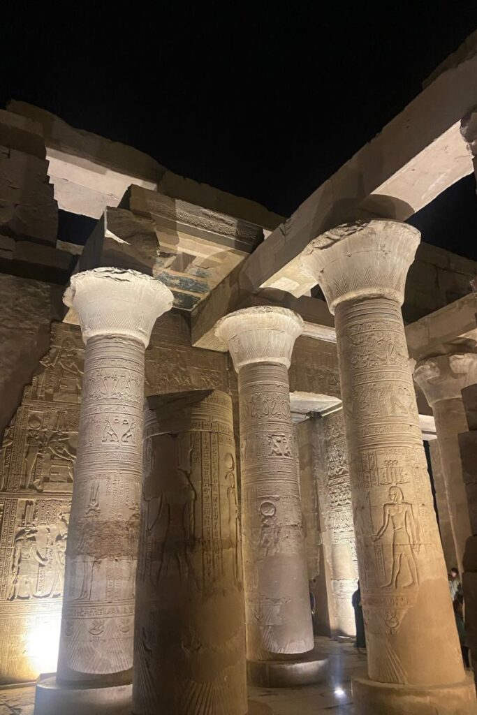 Inside Kom Ombo Temple at night with towering columns covered in hieroglyphs, evoking the ancient reverence for crocodile gods and highlighting what to see at this Nile-side temple.