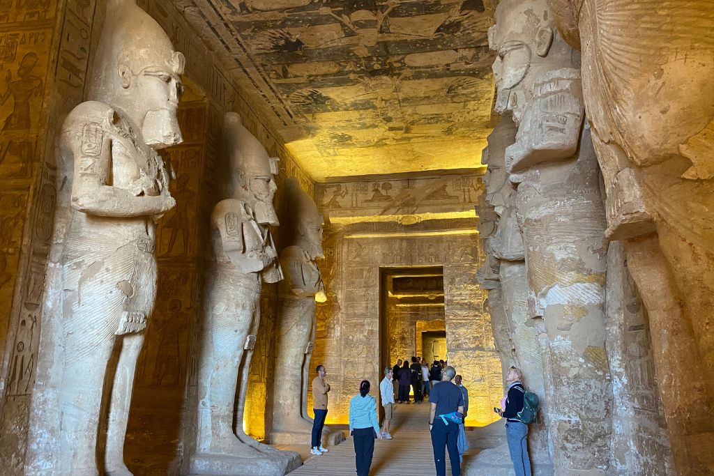 Interior of the Abu Simbel temple filled with visitors admiring massive statues and carvings—capturing the awe of an Abu Simbel guide-led tour or a day trip to Abu Simbel.