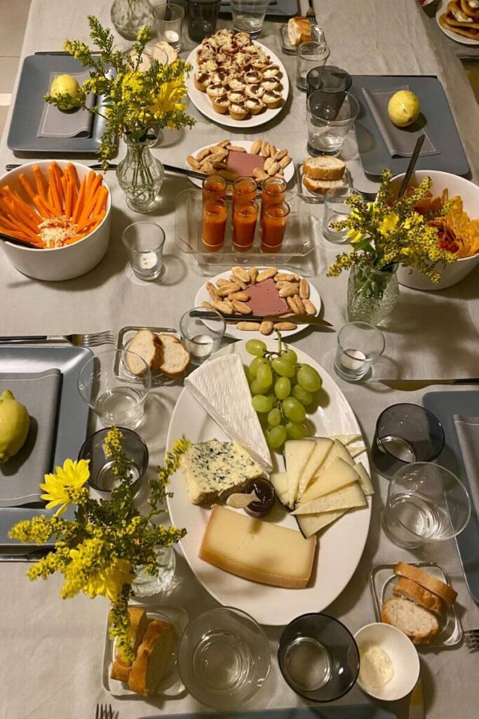 A stylish cheese and snack spread laid out with elegant tableware and florals, suggesting a sophisticated solo dining moment at home or in a lounge setting. Great for “going out solo” or “how to enjoy solo dining” visuals
