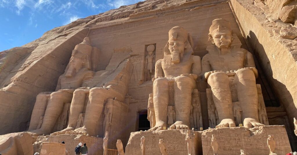 Wide shot of Abu Simbel’s grand facade with tourists below, emphasizing the scale of this site; one of the most popular destinations when visiting Abu Simbel from Aswan or considering an Abu Simbel day trip in Egypt