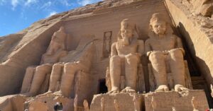 Wide shot of Abu Simbel’s grand facade with tourists below, emphasizing the scale of this site; one of the most popular destinations when visiting Abu Simbel from Aswan or considering an Abu Simbel day trip in Egypt