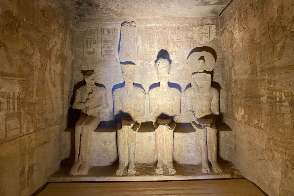 Illuminated sanctuary inside Abu Simbel showing four divine seated figures carved into stone; one of the top things to see on a trip to Abu Simbel from Aswan or part of a guided Abu Simbel tour.