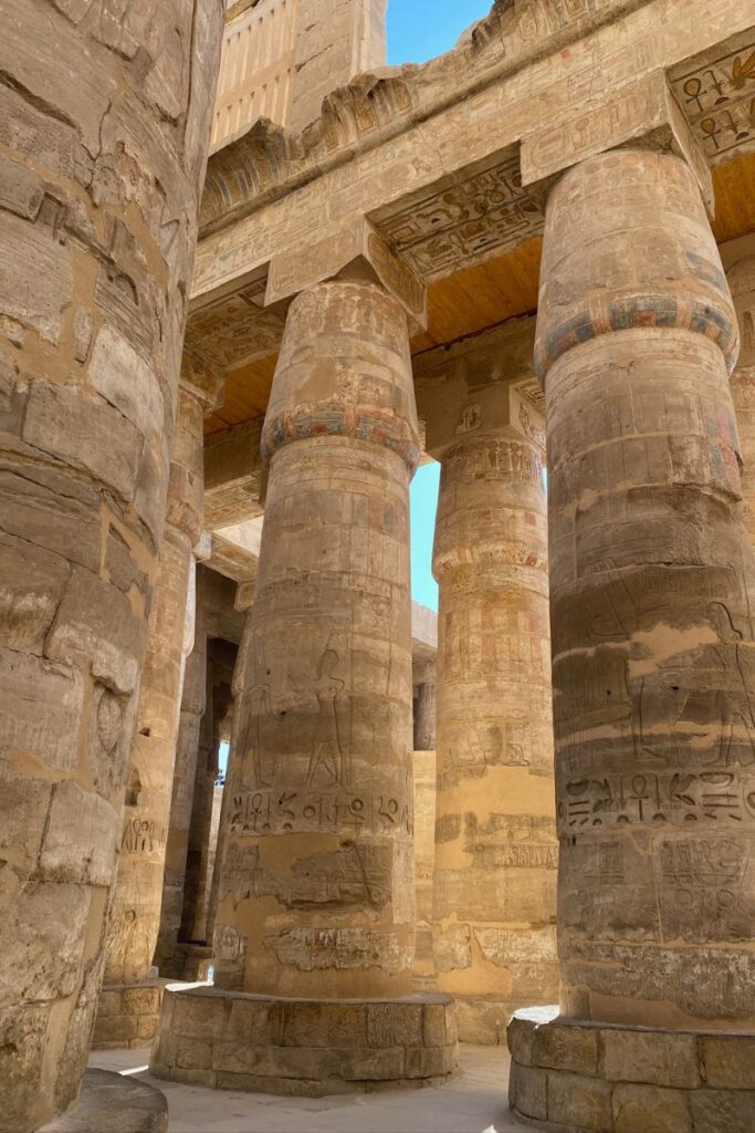 Majestic sandstone columns inside an ancient Egyptian temple with detailed hieroglyphics. A must-have visual for Luxor and Aswan trip content, highlighting excursions available during a Nile cruise from Luxor to Aswan.