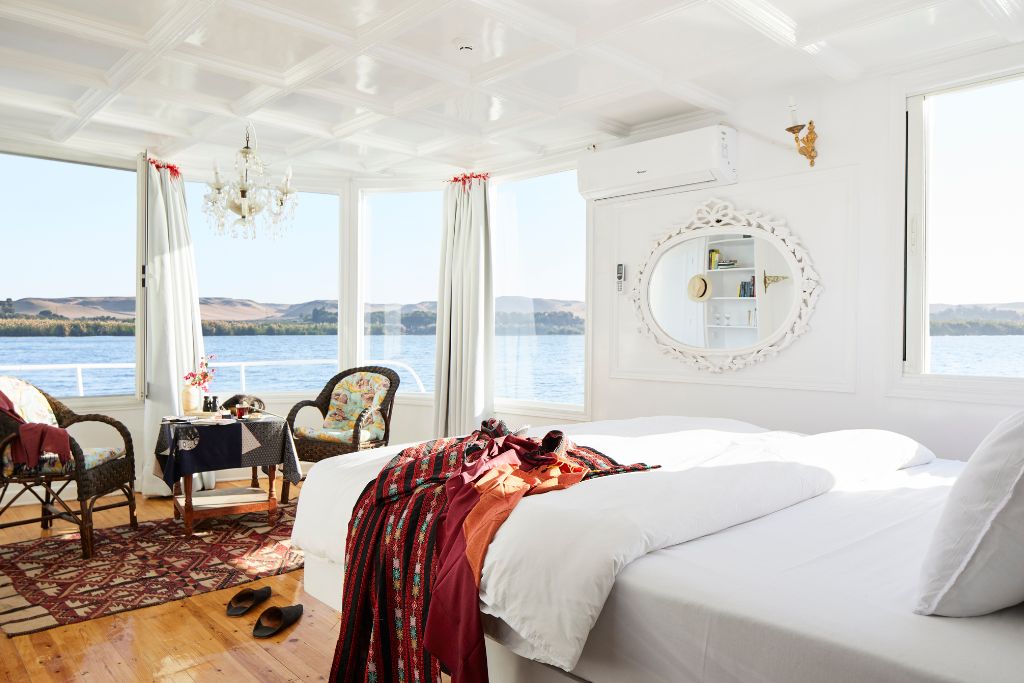 Bright, airy hotel room with large windows overlooking the Nile River in Luxor, Egypt; this elegant space highlights one of the best hotels in Luxor for Nile views and luxurious comfort.