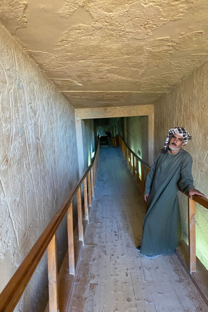 A close-up view of a tomb’s corridor inside Luxor Valley of the Kings, showing narrow passageways with textured ancient walls, complete with carved inscriptions. The rough stone pathway invites visitors to walk through the interior of one of the best-preserved tombs in Egypt’s Valley of the Kings.