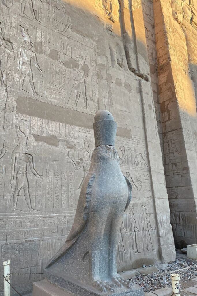 Statue of falcon-headed god Horus in front of engraved temple walls. A prime highlight for a Luxor day trip and part of the essential temples of Luxor.