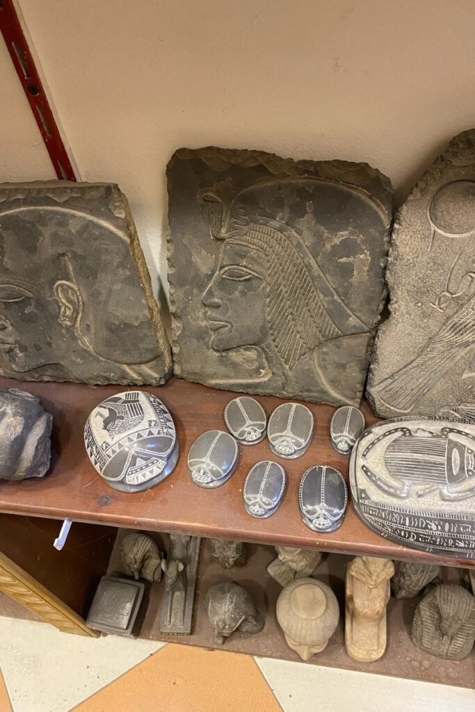 Display of ancient Egyptian stone carvings and scarab souvenirs with detailed etchings—shopping for replicas is one of the unique things to do in Luxor Egypt.